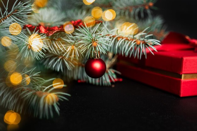 Composición navideña. Un árbol de Navidad decorado con juguetes y una guirnalda y regalos al lado. Foto de alta calidad