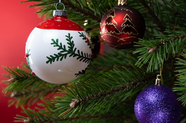 Composición navideña Bolas en un árbol de Navidad en primer plano sobre un fondo rojo