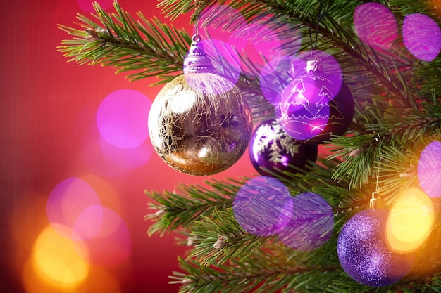 Composición navideña Bolas en un árbol de Navidad en primer plano sobre un fondo rojo