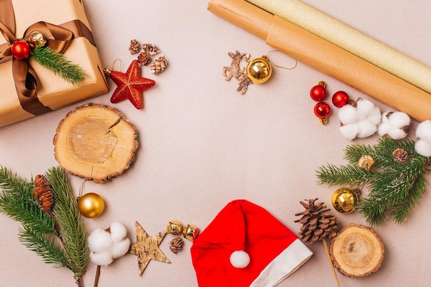 Foto composición navideña con caja de regalo ecológica hecha a mano rama de abeto y decoraciones sobre fondo gris vista superior con espacio de copia