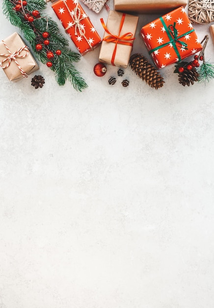 Composición navideña con cajas de regalo, ramas de abeto, piñas y adornos sobre un fondo blanco. Endecha plana, espacio de copia. ¡Feliz navidad y próspero año nuevo!