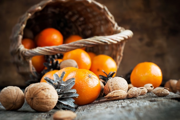 Composición navideña con canasta, frutas, nueces.