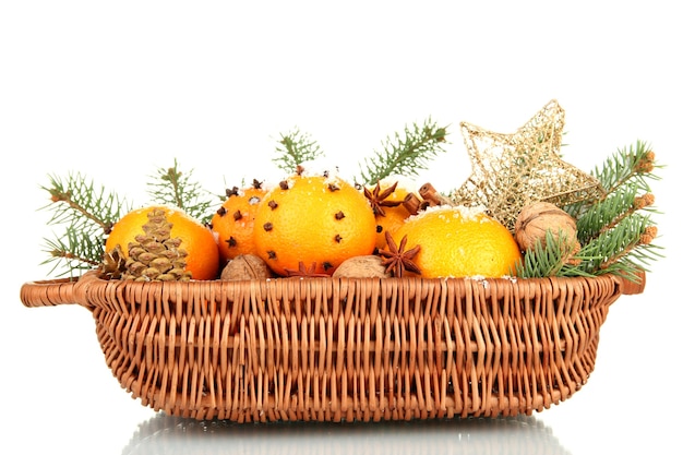 Composición navideña en canasta con naranjas y abeto, aislado en blanco