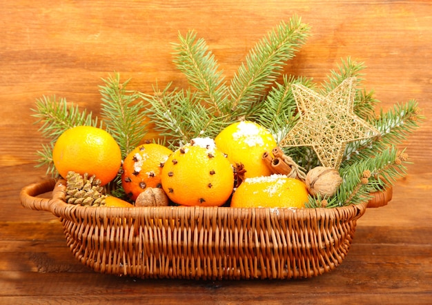 Composición navideña en canasta con naranjas y abeto