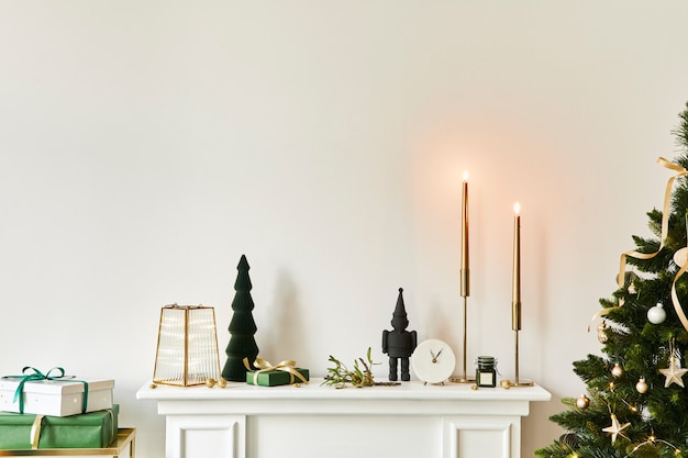 Composición navideña en la chimenea blanca en el interior de la sala de estar con una hermosa decoración. Árbol de Navidad y corona, velas, estrellas, luz. Copie el espacio. Plantilla.