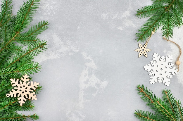 Composición navideña con copos de nieve de madera y ramas de abeto