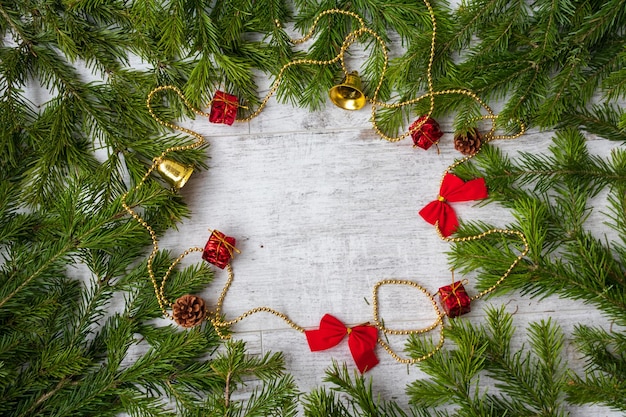 Composición navideña Decoraciones para árboles de Navidad ramas de abeto sobre fondo blanco de madera Espacio de copia de vista superior plana