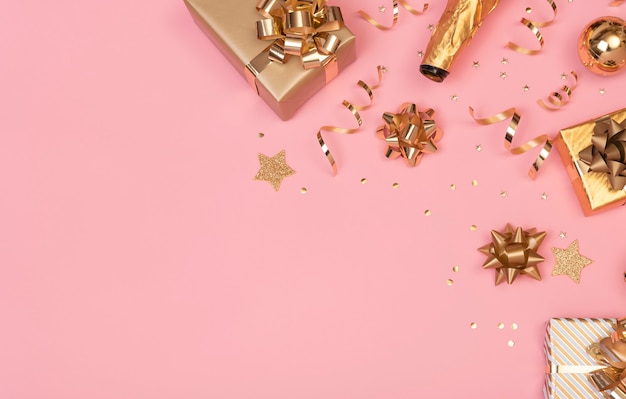 Composición navideña con decoraciones y caja de regalo con confeti estrella en rosa pastel. invierno,. Endecha plana, vista superior, copyspace.