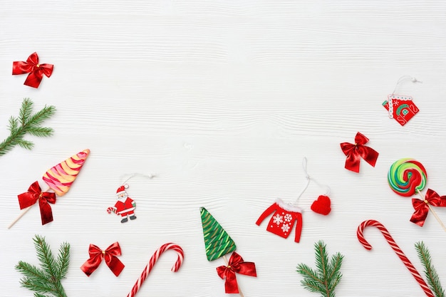 Composición navideña Dulces navideños y bastones de caramelo, ramas de pino y juguetes de madera de Año Nuevo.