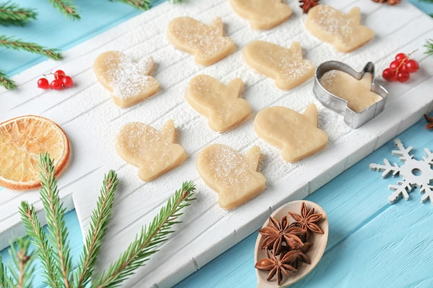 Composición navideña con galletas crudas y ramas de abeto en mesa de madera