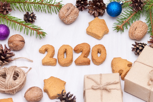 Composición navideña. Galletas de jengibre de Navidad, galletas en forma de números 2020, ramas de abeto, regalos. Año nuevo 2020. Vista plana, vista superior.