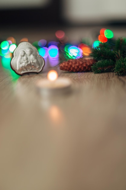 Composición navideña del icono de la iglesia sobre un fondo de madera con luz colorida