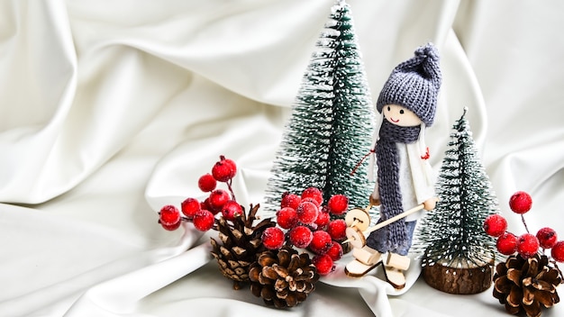 Composición navideña con muñecos de esquí y abetos adornos festivos en seda. Tarjeta de felicitación de Navidad o año nuevo. Copie el espacio. Color champán de moda