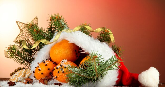 Composición navideña con naranjas y abeto en sombrero de Santa Claus