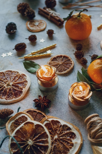 Composición navideña o de Año Nuevo con mandarinas, naranjas secas, regalos de canela, dulces y juguetes en una mesa rústica ligera