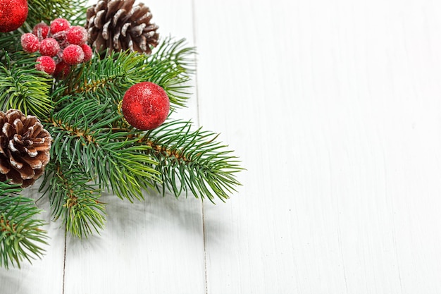 Composición navideña rama de árbol de Navidad con conos de juguetes sobre un fondo de madera