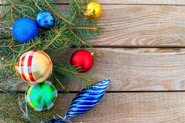 Composición navideña con ramas de abeto y adornos navideños en mesa de madera. Vista superior, espacio de copia