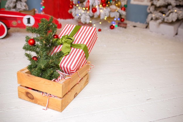 Composición navideña Regalo ramas de abeto y bolas de árbol de navidad sobre fondo de madera blanca