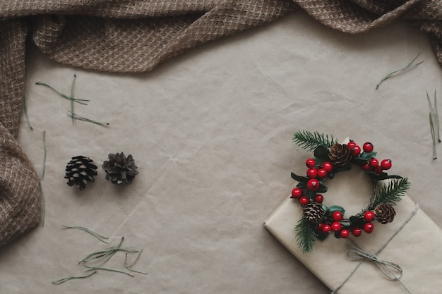 Composición navideña. Regalo, ramas de abeto, bolas sobre fondo de papel artesanal. Navidad, invierno, concepto de año nuevo. Endecha plana, vista superior, espacio de copia.
