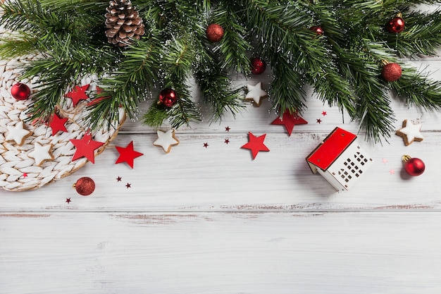 Composición navideña. Regalos, ramas de abeto, adornos rojos sobre madera blanca. Navidad, invierno, concepto de vacaciones de año nuevo. Endecha plana, vista superior, espacio de copia