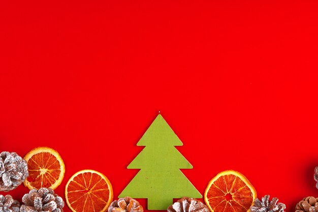 Composición navideña sobre fondo rojo con piñas