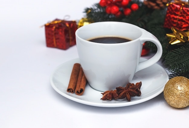 Composición navideña con taza de café, especias y adornos navideños.