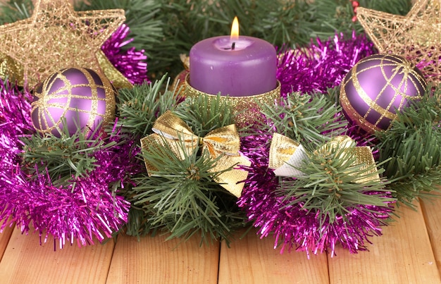 Composición navideña con velas y adornos en colores morado y dorado