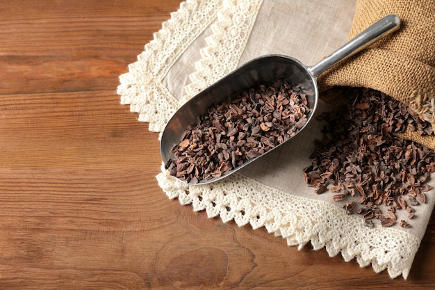 Composición con nibs de cacao sobre mesa de madera