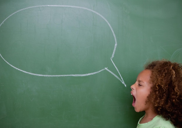 Foto composición de niña gritando con espacio de copia de burbujas de discurso de tiza vacía en la pizarra