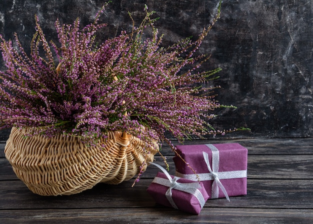 Composición otoñal de brezo en una canasta de mimbre y regalos bodegón