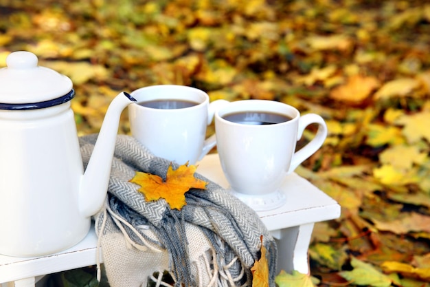 Composición de otoño con bebida caliente en el fondo de la naturaleza