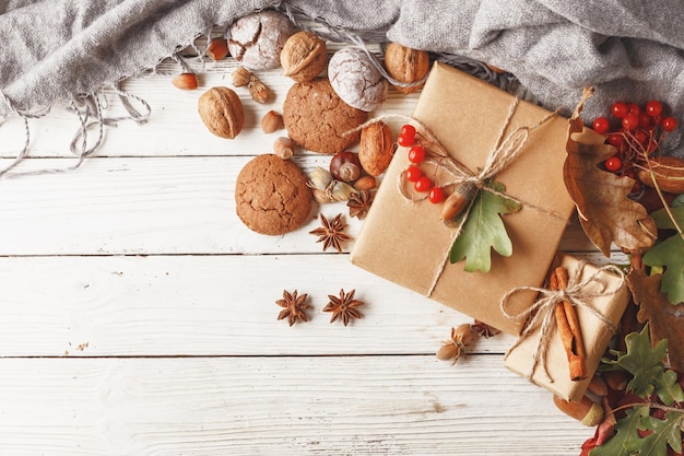 Composición de otoño Caja de regalo hojas de otoño frutas y especias en una mesa de madera blanca Vista superior Espacio de copia