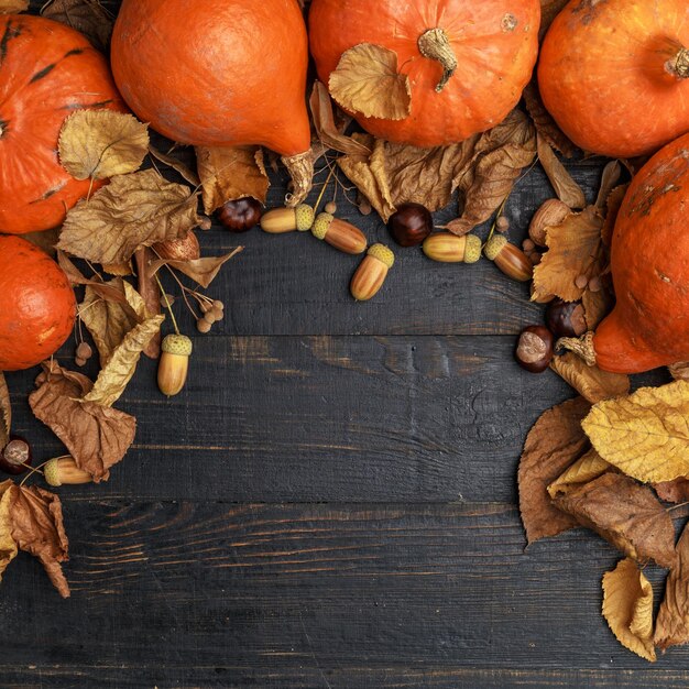 Composición de otoño con hojas secas y calabazas maduras en una mesa de madera oscura Vista superior Espacio de copia