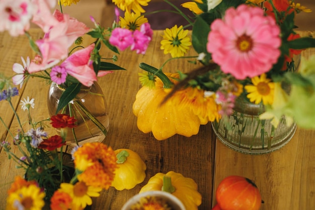 Foto composición de otoño en mesa rústica coloridas flores de otoño en florero calabazas calabazas cosecha