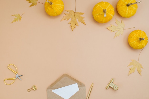 Composición de otoño Sobre hojas de arce secas calabazas amarillas sobre un fondo beige