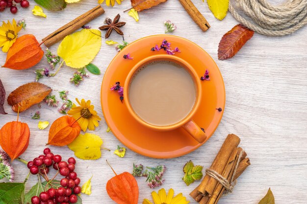 Composición de otoño taza de café sobre una mesa con flores y hojas, vista superior, imagen de fondo