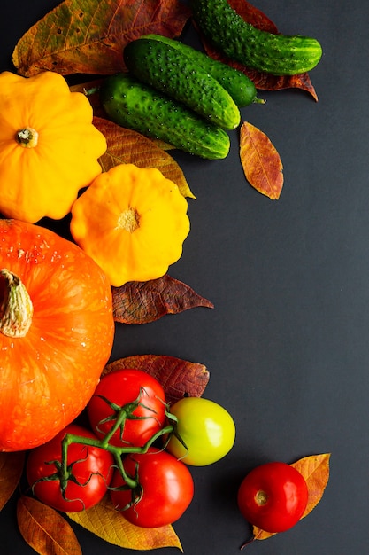 Composición de otoño de verduras y hojas en el escritorio negro