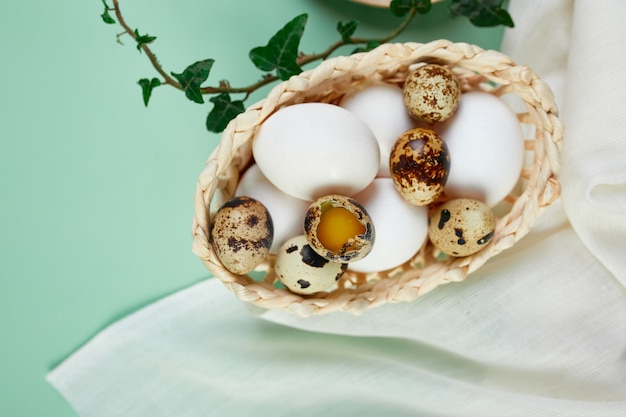 Composición de Pascua con hojas verdes y huevos de Pascua sobre una superficie verde