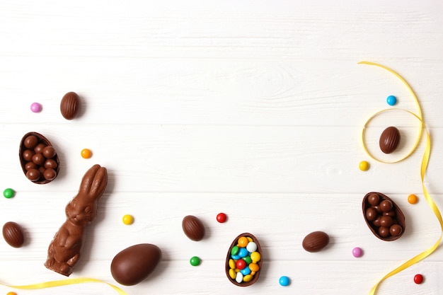 Foto composición de pascua con huevos de chocolate y conejo de chocolate sobre fondo de madera, lugar para el texto. dulces de pascua. foto de alta calidad