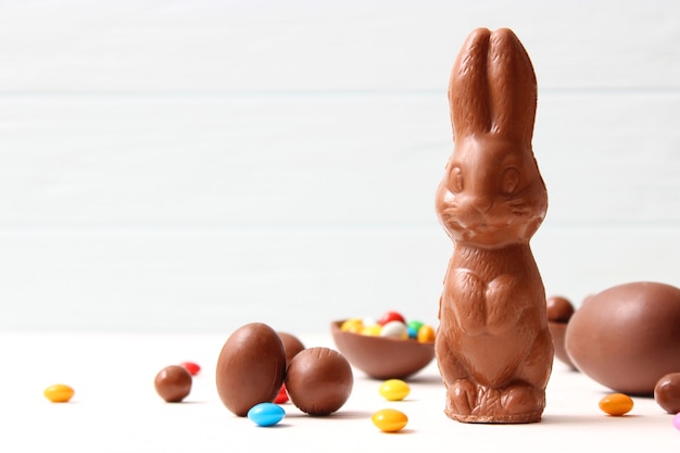 Foto composición de pascua con huevos de chocolate y conejo de chocolate sobre fondo de madera