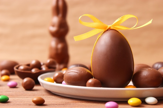 Composición de Pascua con huevos de chocolate y conejo de chocolate sobre fondo de madera