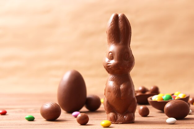 Composición de pascua con huevos de chocolate y conejo de chocolate sobre fondo de madera