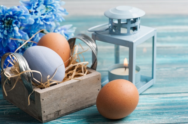 Composición de Pascua con huevos, flores azules y velas