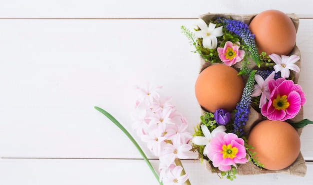 Composición de pascua de huevos de gallina y flores de primavera.