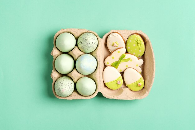 Composición de Pascua de huevos pintados artesanalmente en caja de papel y galletas horneadas en verde.