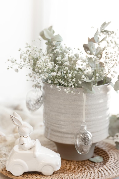 Composición de Pascua con liebre de cerámica y flores de gipsófila