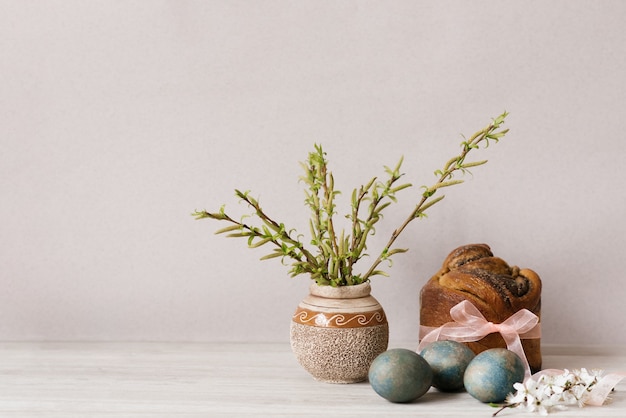 Composición de Pascua con pan dulce ortodoxo, kulich y huevos sobre fondo claro.