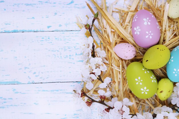 Composición de Pascua con ramas floridas en el primer plano de la mesa de madera