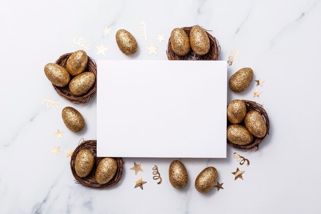 Composición de Pascua Tarjeta en blanco con huevos de oro y nidos