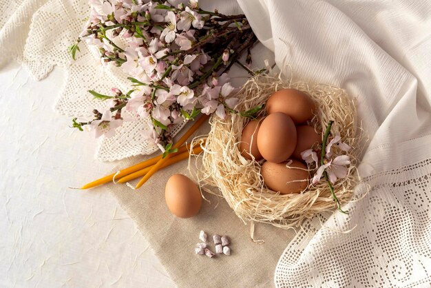 Composición de Pascua Velas huevos incienso y ramas floridas en el primer plano de la mesa